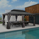 Grey hardtop gazebo with outdoor dining set, string lights, and a pool view. Patio shade solution for outdoor entertaining.