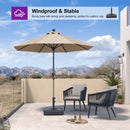 Beige patio umbrella with sturdy base on a patio, windproof and stable for outdoor use.