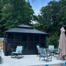 Gray sunroom hardtop gazebo on a patio with outdoor furniture, patio shade solution.