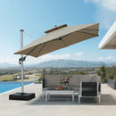 Beige cantilever patio umbrella providing shade over outdoor furniture, overlooking a scenic landscape.