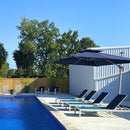 Cantilever patio umbrella with blue canopy over chaise lounges by pool, outdoor patio shade solution