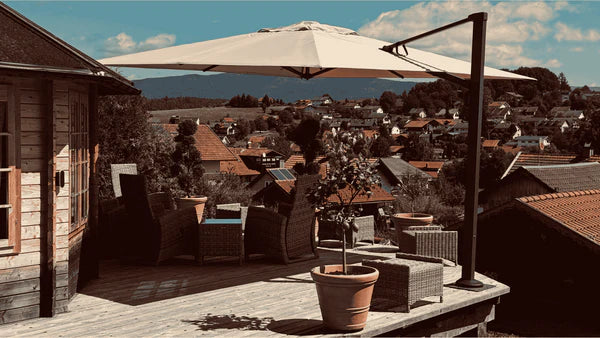 Large cantilever patio umbrella over a deck with outdoor furniture