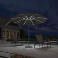 PURPLE LEAF dark grey market umbrella with LED lights on patio at night