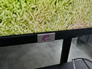 Silver plaque with Purple Leaf logo on black bezel of weatherproof outdoor TV