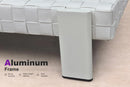 Aluminum frame details of a white rattan chaise lounge, rust-resistant with sturdy structure for outdoor use.