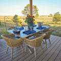 PURPLE LEAF Champagne outdoor dining set: aluminum table, rattan chairs with cushions on deck.