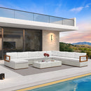 White L-shaped patio conversation set with ottoman and coffee table on a poolside patio